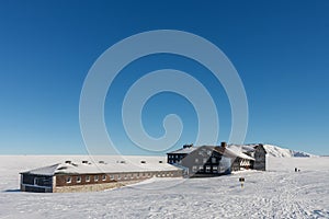 Meadow Hut , ski lodge, krkonose mountains Czech Republic. Winter morning, on background Snezka, mountain on the border between