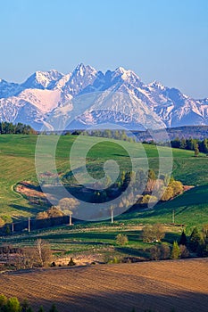 Meadows near Vysne Repase village in Levocske vrchy mountains with High Tatras on horizon