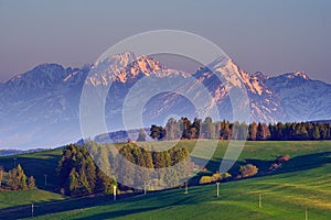 Meadows near Vysne Repase village in Levocske vrchy mountains with High Tatras on horizon