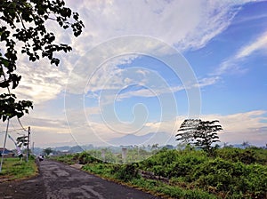 Meadows trees road with artistic blue sky clouds