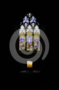 The Meager light of a Church Candle in dark a Church