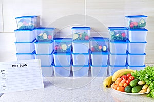 A meal plan for a week on a white table among set of plastic containers for food and food. Proper nutrition during the week