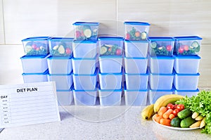 A meal plan for a week on a white table among set of plastic containers for food and food. Proper nutrition during the week