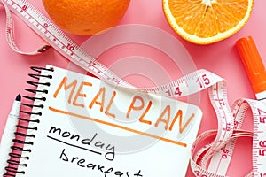 Meal plan for weight loss with orange on pink surface