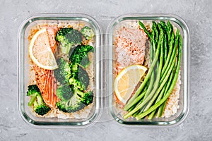 Meal prep lunch box containers with baked salmon fish, rice, green broccoli and asparagus