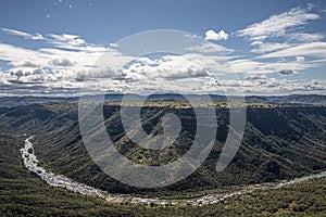 Meandering River Flowing Through Steep Tree-Lined Valley