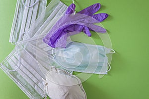 Means of protection: various masks, gloves on green background