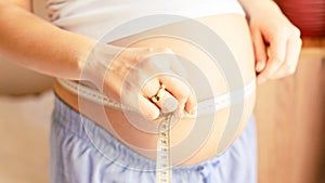 Measure body pregnancy woman. Happy beautiful pregnant woman with tape measuring belly. Concept of pregnancy, maternity