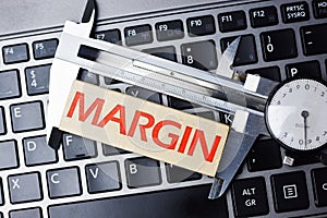 Measure margin of profit concept with caliper tool on computer keyboard