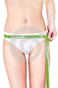 Measure tape around slim woman's hip