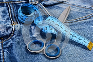 Measure tape wound around metal scissors as making clothes concept