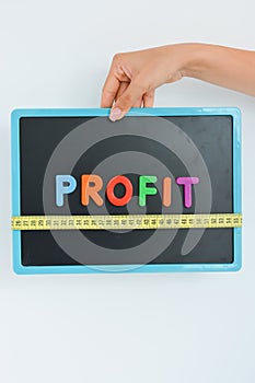 Measure your profit concept written as magnetic colored letter blocks with scale