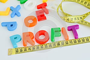 Measure your profit concept written with magnetic colored letter blocks with measuring tape