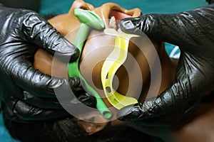 Measurement of nasopharyngeal and Oropharyngeal Airway tubes by stuff in a black gloves on a simulation mannequin dummy during