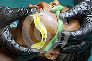 Measurement of nasopharyngeal and Oropharyngeal Airway tubes by stuff in a black gloves on a simulation mannequin dummy during