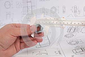 Measurement of nut dimensions with an engineering caliper.