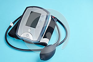 measuring blood pressure with electronic medical device over blue background. copy space