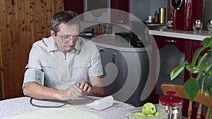 Measuring blood pressure with an electronic tonometer or pulsometer, middle aged Caucasian man independently measures