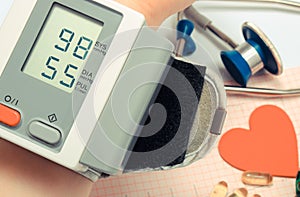 Measuring blood pressure and medical stethoscope with heart shape on electrocardiogram graph. Healthy lifestyles