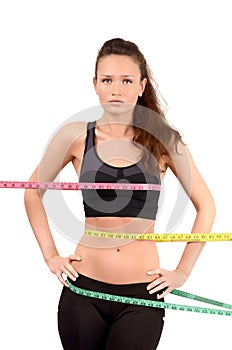 Measuring bust, waist, hips. Beautiful fit girl wrapped with three measuring tapes in inch.