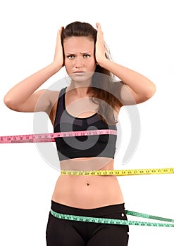 Measuring bust, waist, hips. Beautiful fit girl wrapped with three measuring tapes in inch.