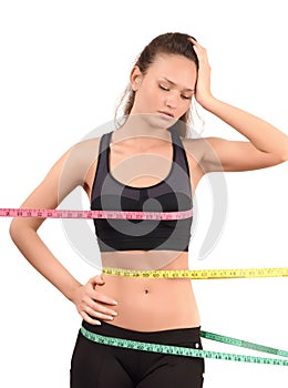 Measuring bust, waist, hips. Beautiful fit girl wrapped with three measuring tapes in inch.