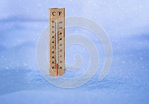 Measuring cold temperature with a wooden thermometer during snow storm