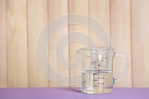 Measuring cup with vinegar on table.