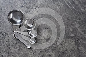 Measuring cups on black concrete background.