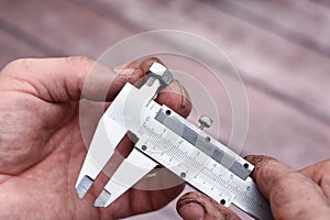 Measuring the diameter of the nut thread with a caliper.