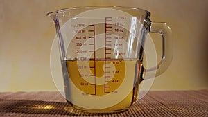 Measuring glass jug with vegetable oil close up shot