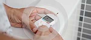 is measuring his blood glucose level, banner format