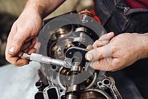 Measuring instrument in hands against the background of the engine at a shallow depth of field