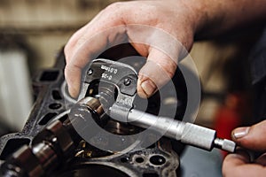 measuring instrument in hands against the background of the engine at a shallow depth of field