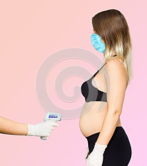 Measuring a pregnant woman`s temperature with a wireless thermometer