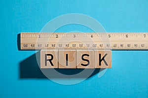 Measuring Risk. Ruler with Risk text on wooden cube
