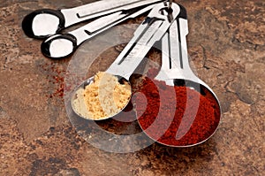 Measuring spoons with red and yellow spices