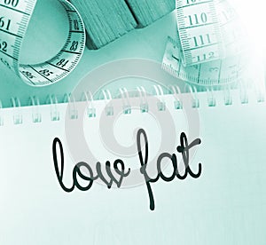Measuring tape and copybook with Low fat words. Healthcare concept
