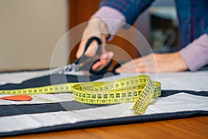 Measuring tape with dressmaker cutting in background