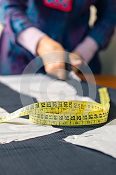 Measuring tape with dressmaker cutting in background