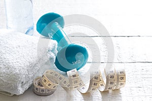 Measuring tape and dumbbells sport and lose weight background concept