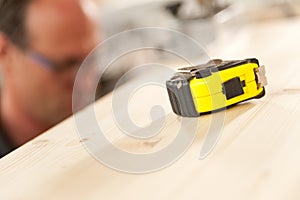 Measuring tape in focus in carpenter workshop