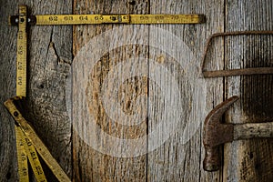 Measuring Tape Hammer and Saw on Rustic Old Wood