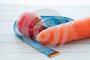 Measuring tape, juicy tomato and carrot, the concept of healthy eating and losing weight