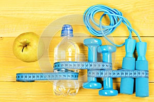 Measuring tape, jump rope and dumbbells, top view