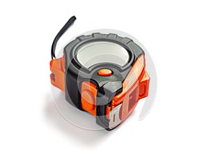 Measuring tape in an orange and black plastic case, with a metal ruler, on a white background