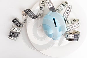 a measuring tape and a piggy bank in a white plate