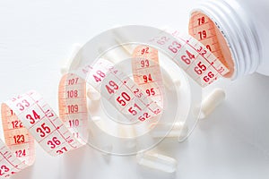 Measuring tape in a pills bottle on a white background