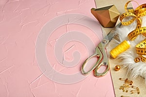 Measuring tape with scissors and sewing accessories on color textured background