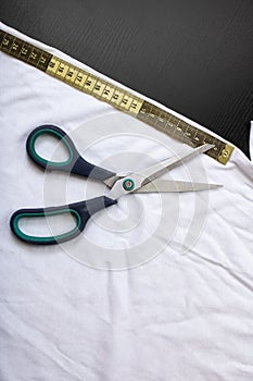 Measuring tape and scissors on white fabric
